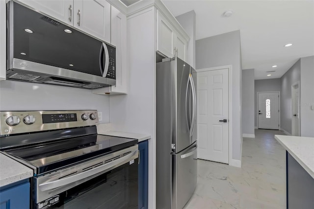 kitchen with white cabinetry, stainless steel appliances, light stone countertops, and blue cabinetry