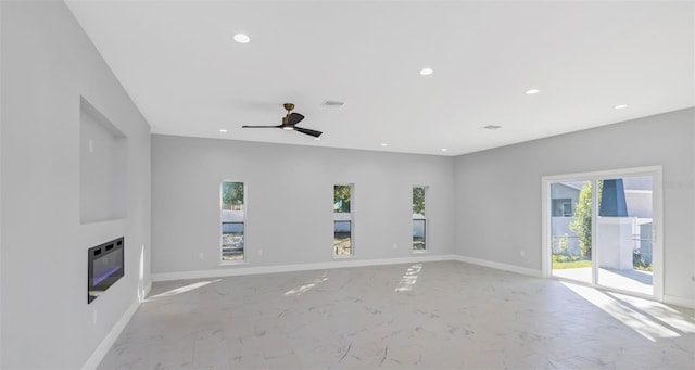 unfurnished living room with heating unit and ceiling fan