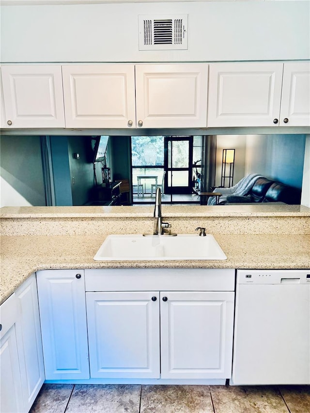 kitchen featuring dishwasher, light stone countertops, sink, and white cabinets