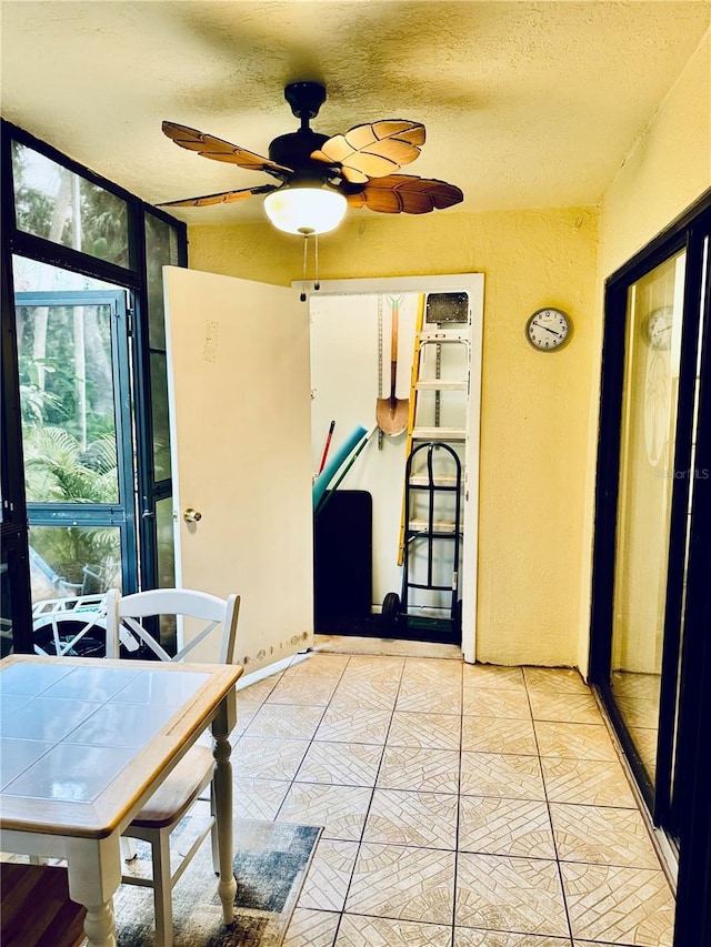 unfurnished sunroom with ceiling fan