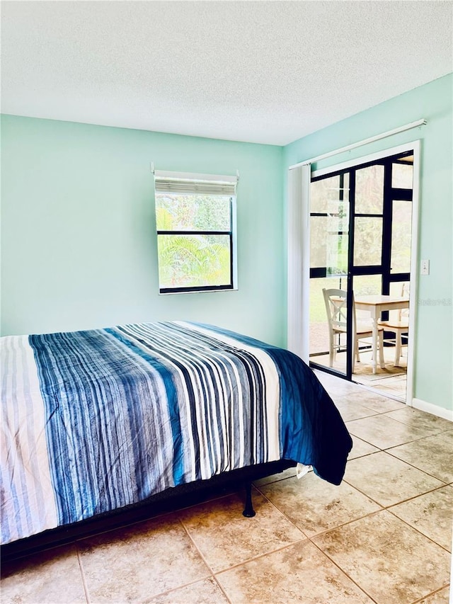 bedroom with light tile patterned floors and a textured ceiling