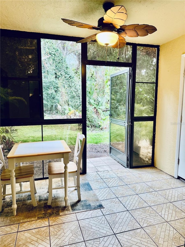 sunroom featuring ceiling fan and a healthy amount of sunlight