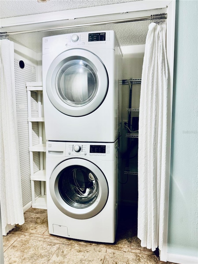 laundry area featuring stacked washer and clothes dryer and a textured ceiling