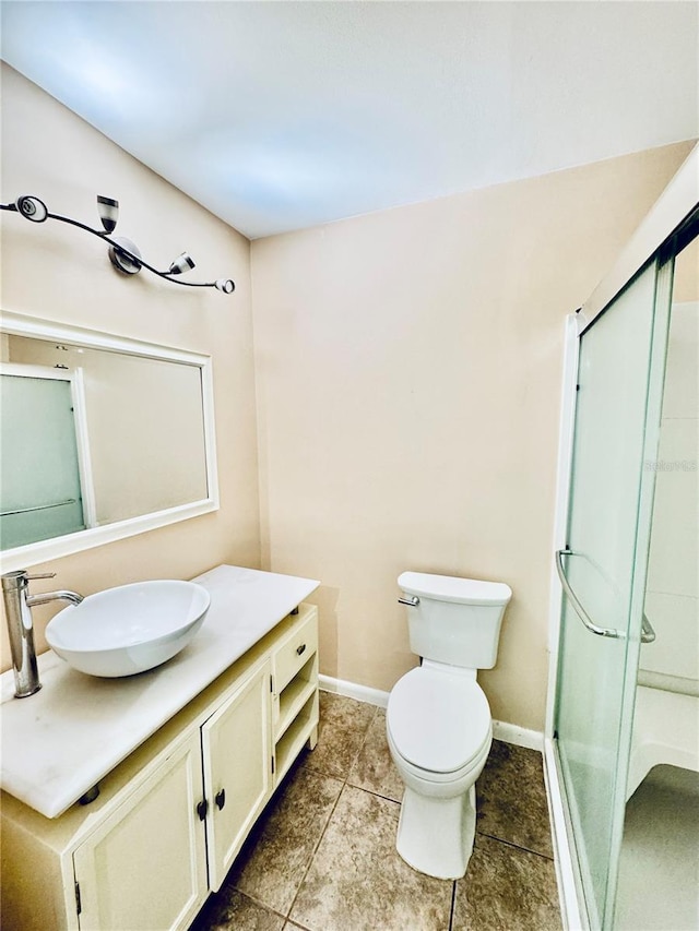 bathroom featuring tile patterned floors, vanity, toilet, and a shower with door