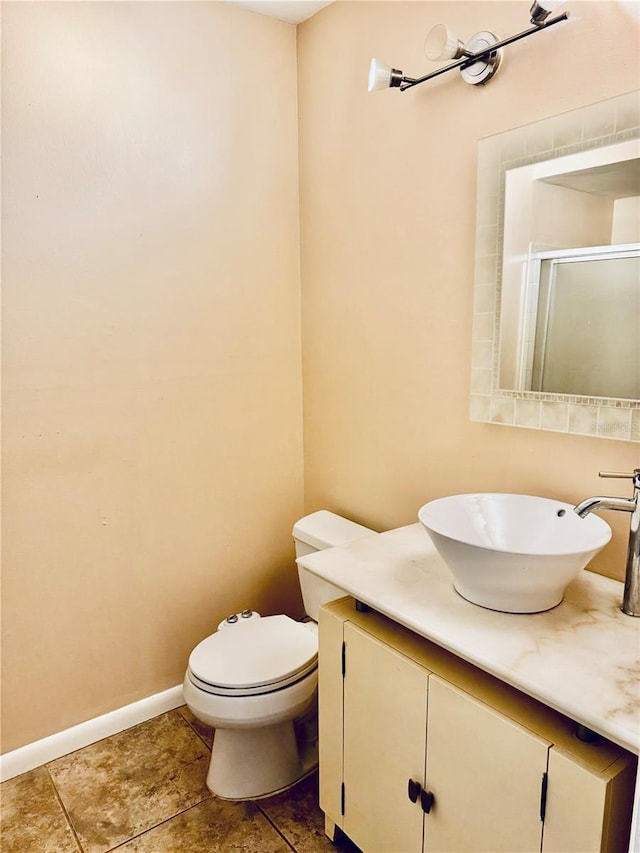 bathroom with vanity, toilet, and a shower with door