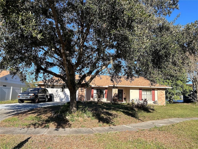 ranch-style house featuring a garage and a front lawn