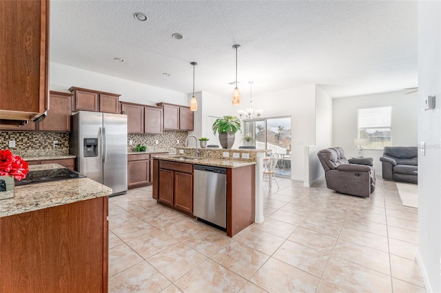 kitchen featuring pendant lighting, stainless steel appliances, tasteful backsplash, and sink