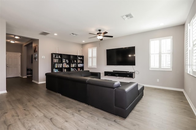 living room featuring ceiling fan and light hardwood / wood-style flooring