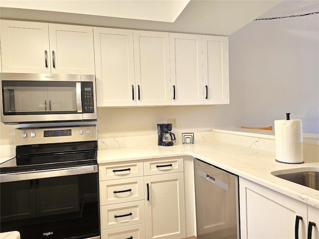 kitchen featuring white cabinets, light stone countertops, and stainless steel appliances