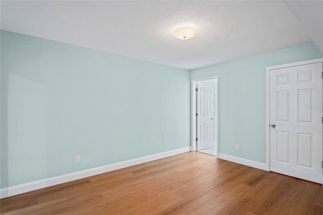 unfurnished bedroom with hardwood / wood-style floors and a textured ceiling