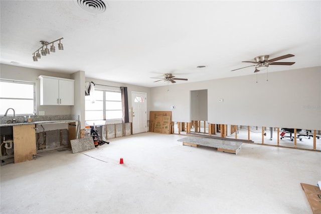 living room with ceiling fan, a healthy amount of sunlight, and sink