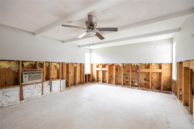 empty room featuring ceiling fan, beam ceiling, an AC wall unit, and a textured ceiling