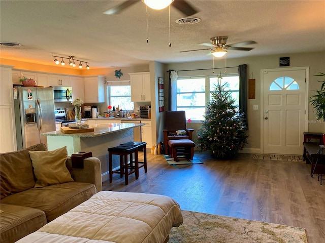 6951 S Shore Dr S, South Pasadena, FL 33707 - living area featuring ceiling fan, a textured ceiling, visible vents, and wood finished floors