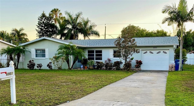 6951 S Shore Dr S, South Pasadena, FL 33707 - ranch-style home featuring a garage, driveway, fence, and a lawn