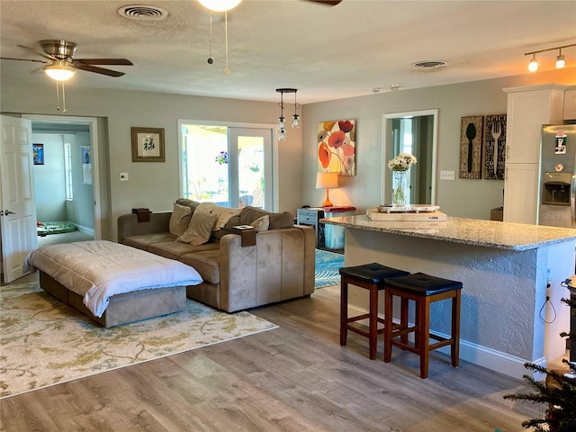 6951 S Shore Dr S, South Pasadena, FL 33707 - living area with a ceiling fan, visible vents, and wood finished floors