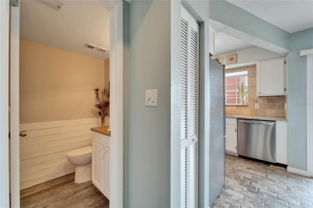 bathroom with vanity, tasteful backsplash, and toilet