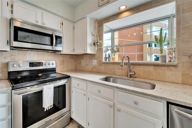 kitchen with a healthy amount of sunlight, sink, white cabinetry, and stainless steel appliances