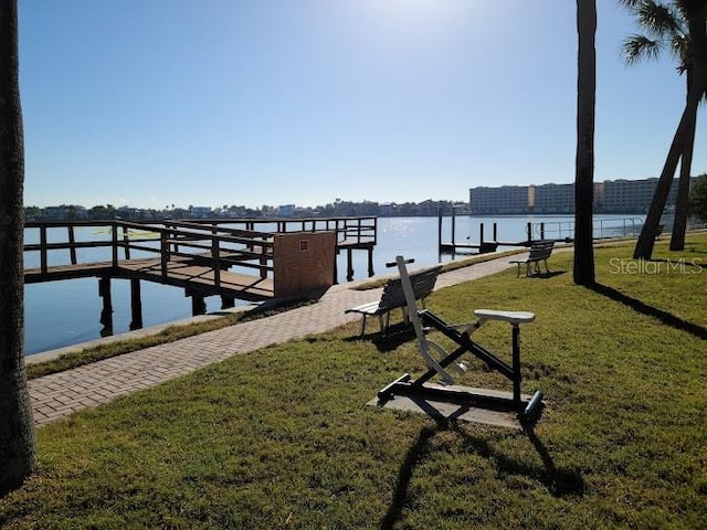 view of dock featuring a water view and a lawn