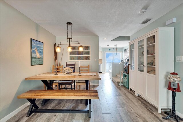 dining space featuring stairs, wood finished floors, and visible vents