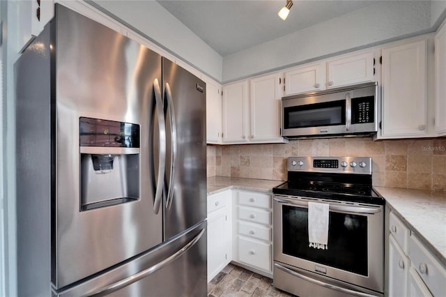 kitchen featuring light stone counters, decorative backsplash, white cabinets, and stainless steel appliances