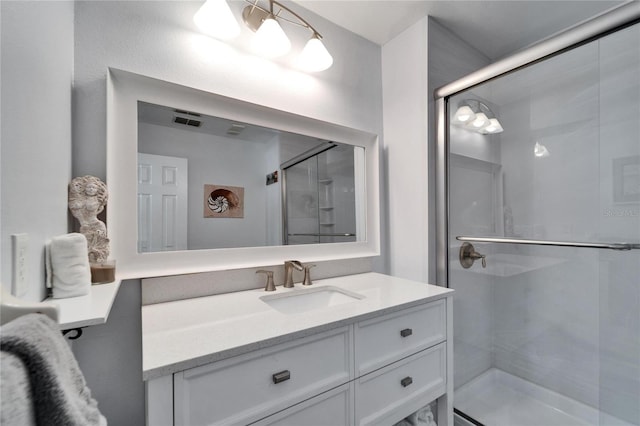 bathroom featuring vanity, visible vents, and a shower stall