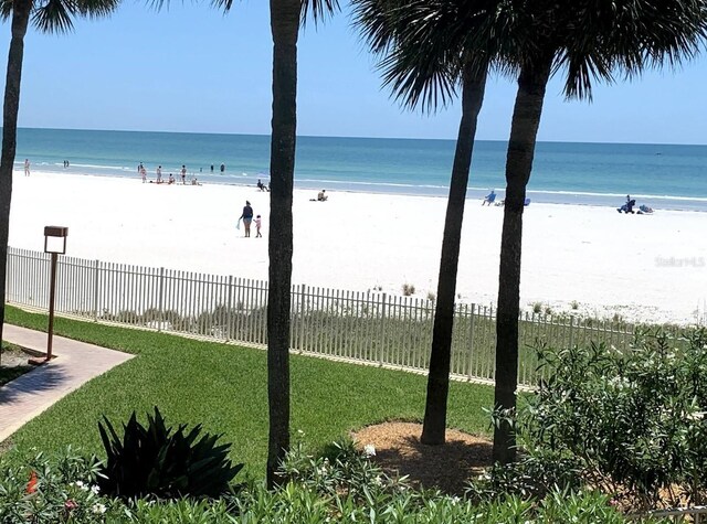 property view of water featuring a view of the beach and fence