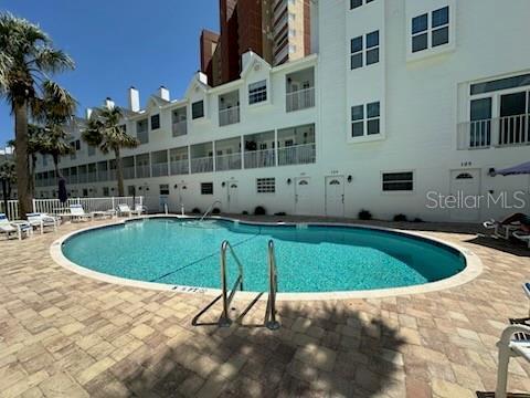 community pool with a patio and fence