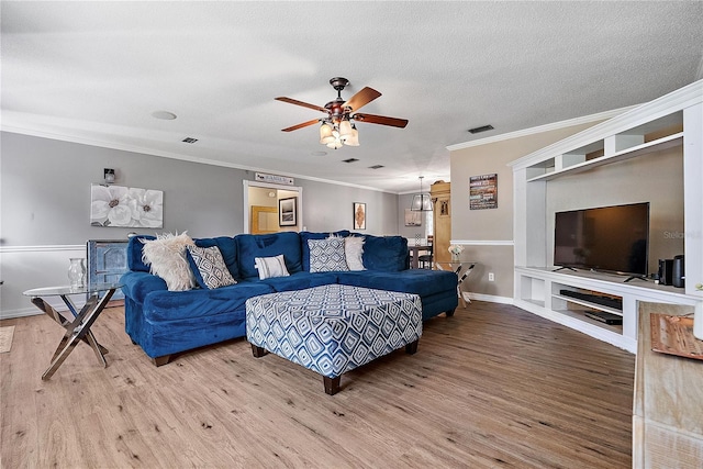 living room featuring a ceiling fan, crown molding, a textured ceiling, and wood finished floors