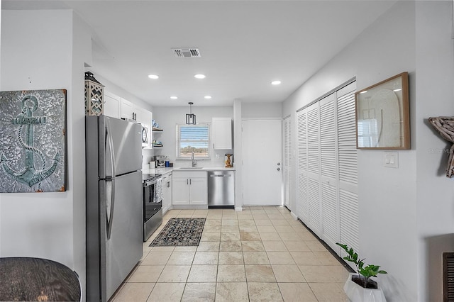 kitchen with white cabinets, sink, appliances with stainless steel finishes, decorative light fixtures, and light tile patterned flooring