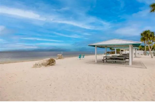 view of property's community with a water view and a view of the beach