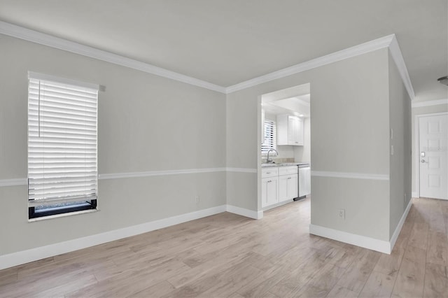 unfurnished room featuring light hardwood / wood-style floors, sink, and crown molding