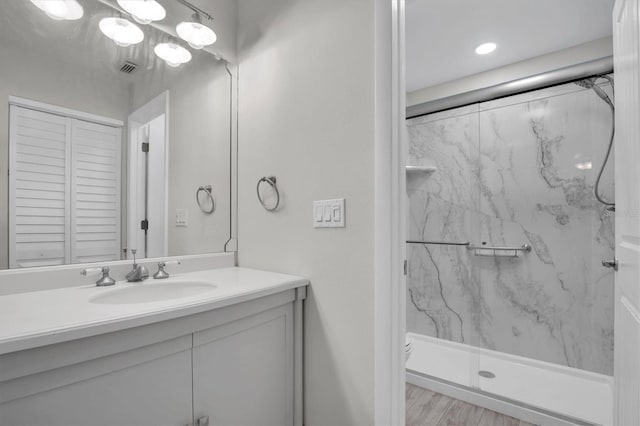 bathroom featuring wood-type flooring, vanity, toilet, and walk in shower