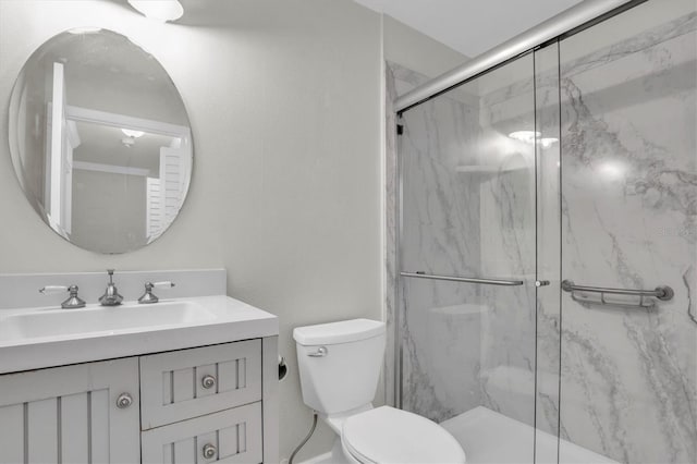 bathroom featuring vanity, toilet, and a shower with door