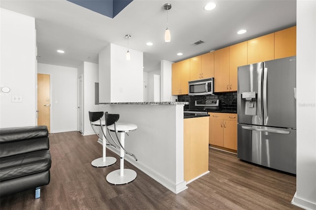 kitchen featuring kitchen peninsula, pendant lighting, stainless steel appliances, and dark wood-type flooring