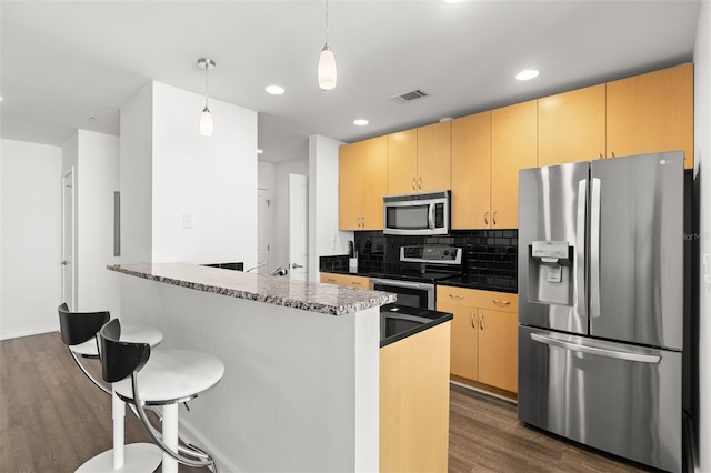 kitchen with dark hardwood / wood-style flooring, pendant lighting, stainless steel appliances, and light brown cabinets