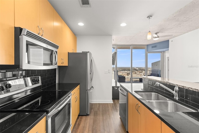 kitchen with tasteful backsplash, stainless steel appliances, ceiling fan, sink, and wood-type flooring