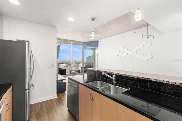 kitchen with floor to ceiling windows, appliances with stainless steel finishes, hanging light fixtures, and sink