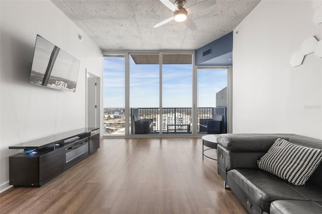 living room with dark hardwood / wood-style floors, ceiling fan, and a wall of windows