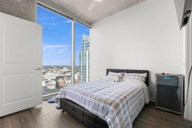 bedroom featuring ceiling fan, floor to ceiling windows, dark hardwood / wood-style flooring, and multiple windows