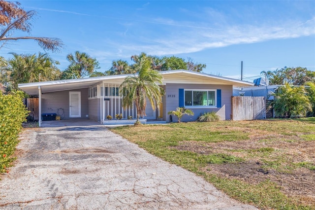 single story home featuring a carport and a front lawn