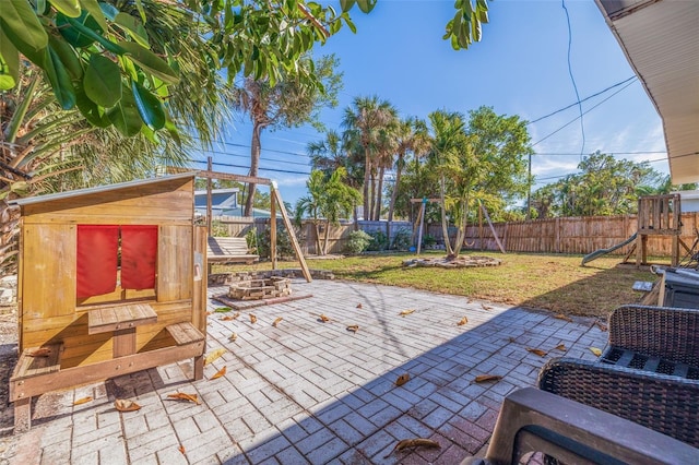 view of patio featuring a playground and a shed