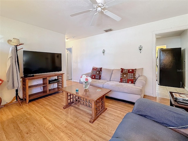 living room featuring light hardwood / wood-style flooring and ceiling fan