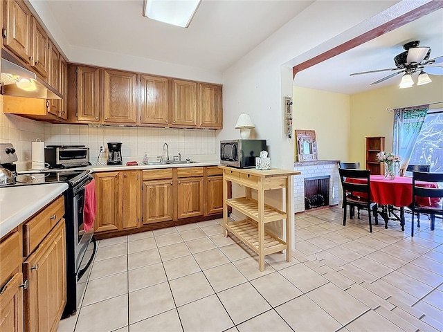 kitchen featuring sink, range with electric stovetop, decorative backsplash, and light tile patterned floors