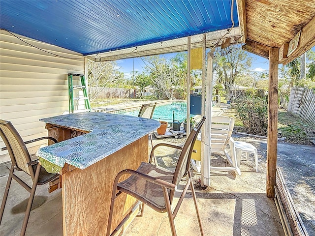 view of patio featuring a fenced in pool and exterior bar