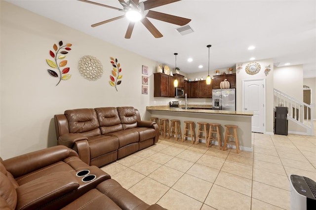 living room with light tile patterned floors, ceiling fan, and sink