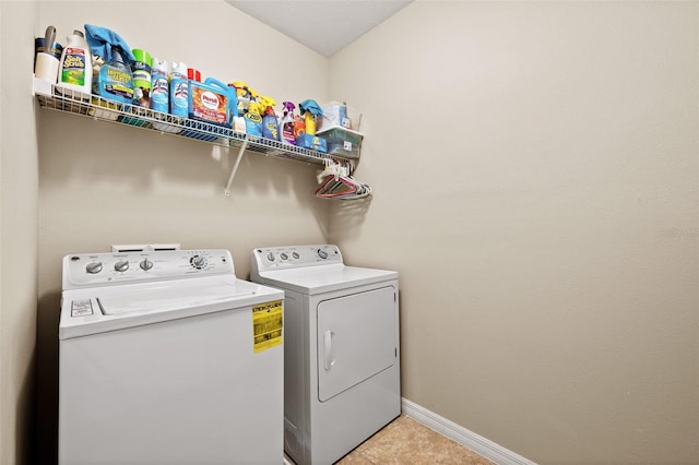 clothes washing area featuring tile patterned floors and washing machine and clothes dryer