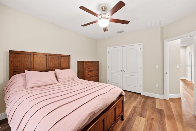 bedroom featuring ceiling fan, light wood-type flooring, and a closet