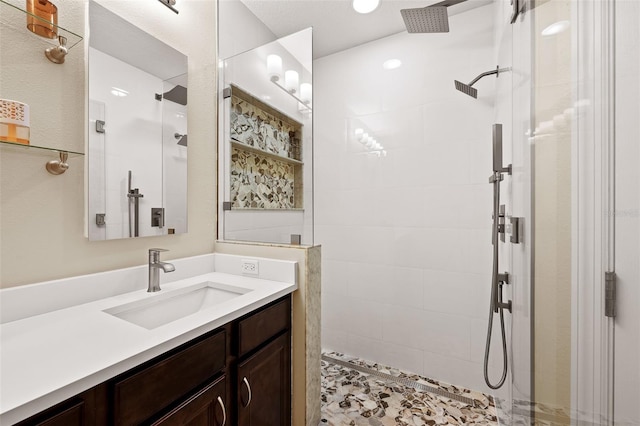 bathroom with vanity and tiled shower