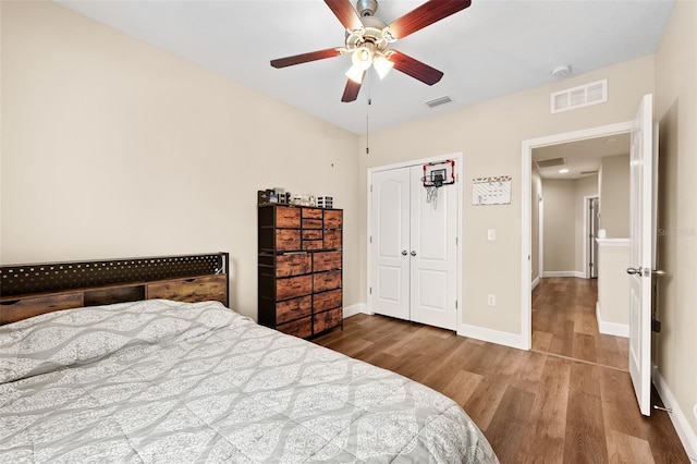 bedroom with ceiling fan, a closet, and hardwood / wood-style flooring