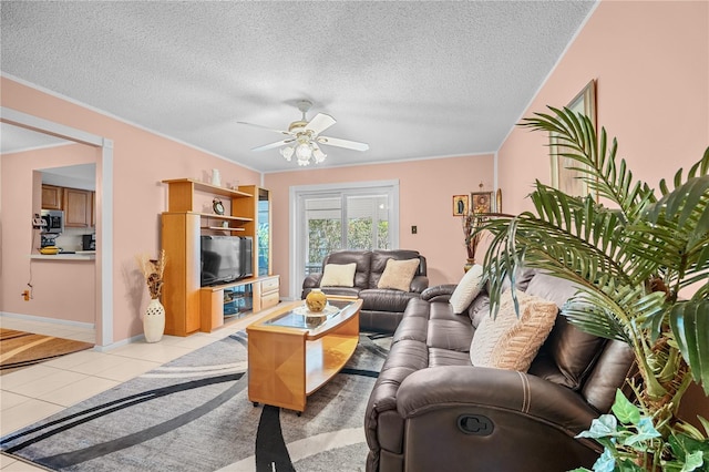 living room featuring ceiling fan, light tile patterned flooring, and a textured ceiling